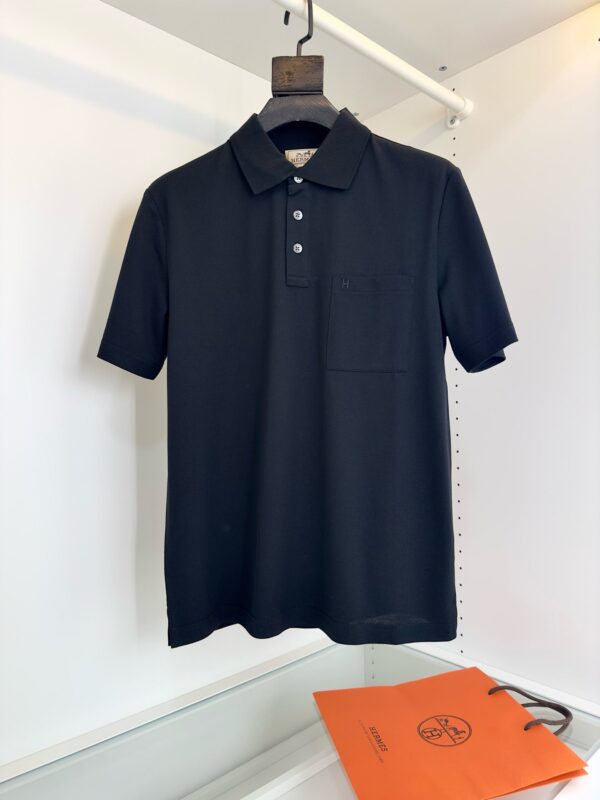 Maglietta polo nera moderna e elegante su appendiabiti, stile minimalista, ideale per ogni occasione.