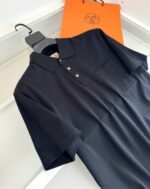 Maglietta polo nera elegante con borsa arancione, stile minimalista e qualità superiore.