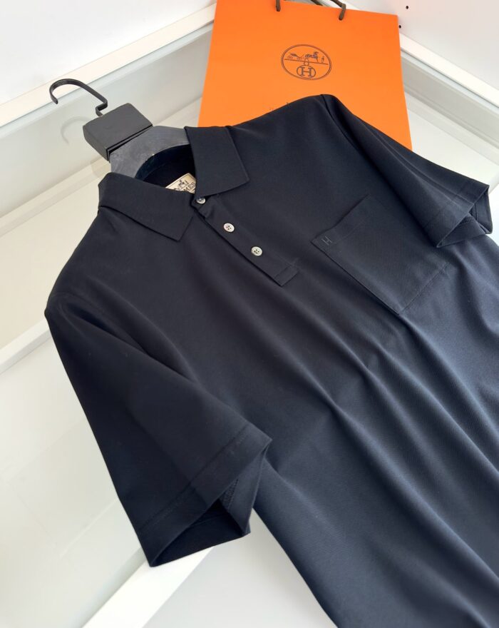 Maglietta polo nera elegante con borsa arancione, stile minimalista e qualità superiore.