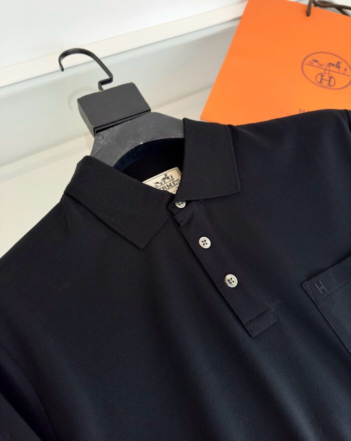 Maglietta polo nera elegante, classica e versatile, con tasca e dettaglio lucido.