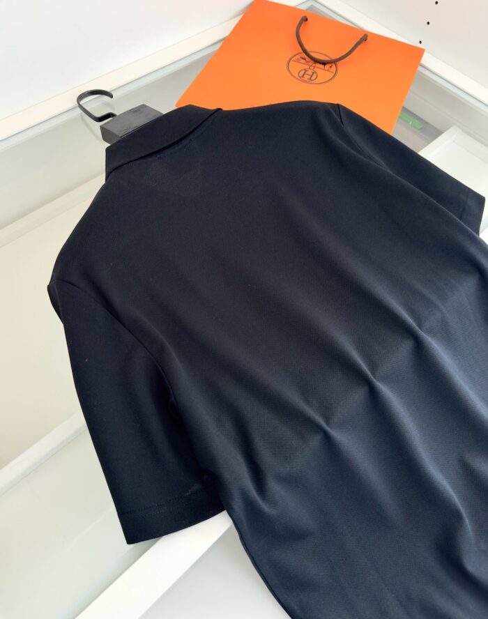 Maglietta polo nera elegante con borsa arancione, stile moderno e raffinato.