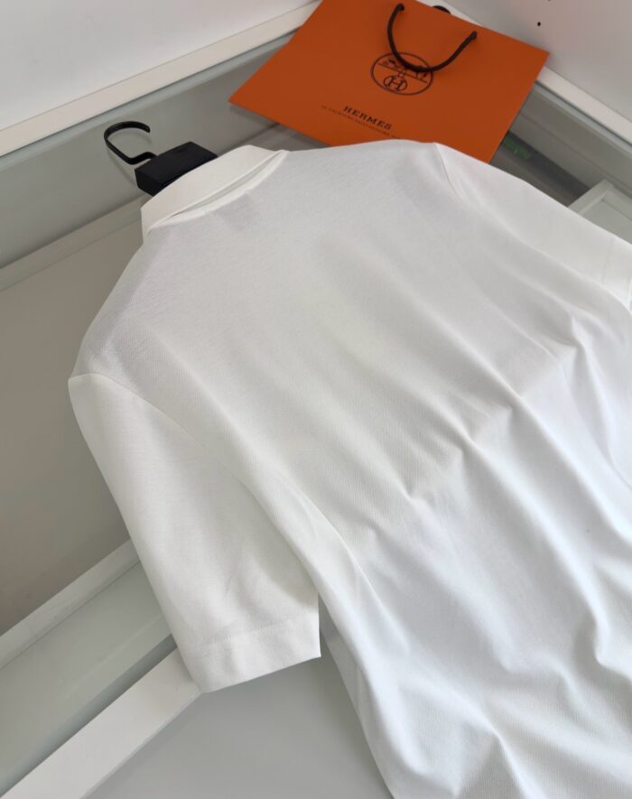Maglietta polo bianca con borsa di design elegante, stile casual e sofisticato, atmosfera moderna e raffinata.