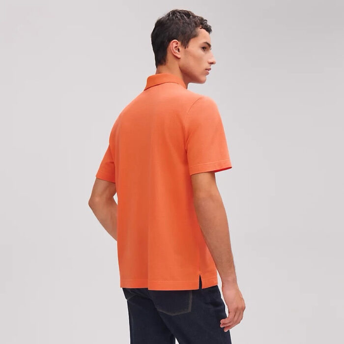 Uomo con polo arancione casual moderno, stile relaxed e abbigliamento estivo elegante.
