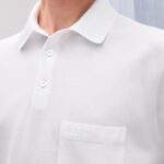 Camicia polo bianca minimalista con colletto, taschino e dettagli eleganti, perfetta per ogni occasione.