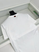 Maglietta bianca minimalista in contenitore trasparente, ideale per stile casual e qualità elevata.
