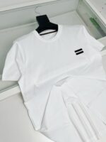 Maglietta bianca semplice con piccolo logo nero, vestirsi con stile minimalista e versatile.
