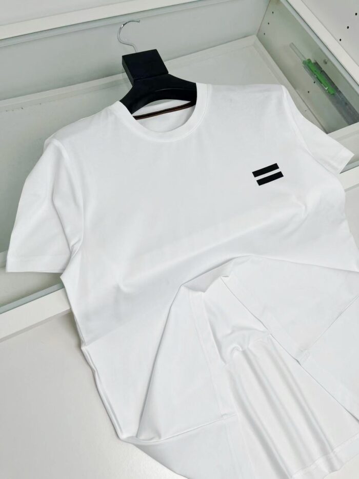Maglietta bianca semplice con piccolo logo nero, vestirsi con stile minimalista e versatile.
