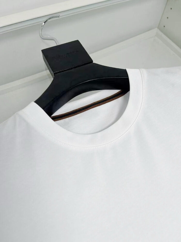 T-shirt bianca minimalista su gancio nero, semplice ed elegante, perfetta per ogni stile casual.
