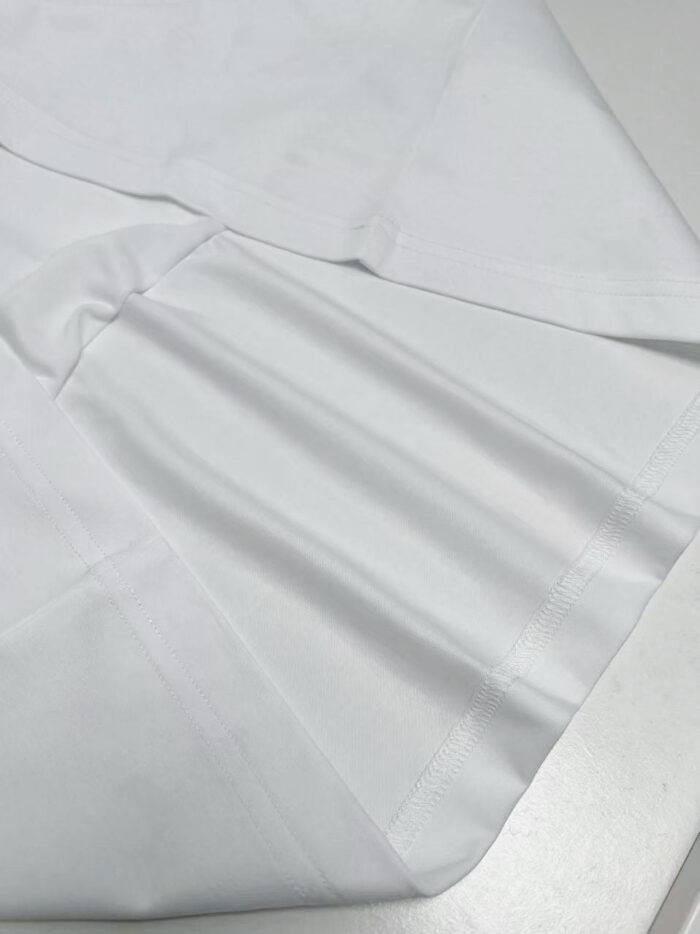 Tessuto bianco morbido e lucido, perfetto per abbigliamento e decorazioni eleganti.