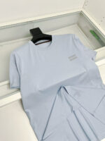 T-shirt blu chiaro minimalista con logo discreto, perfetta per uno stile casual ed elegante.