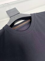 Maglietta nera elegante con collo raffinato e dettagli di qualità, perfetta per uno stile semplice e versatile.