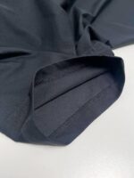 Polsino di camicia nera, tessuto liscio e stile elegante.