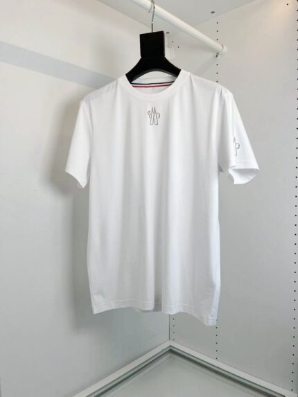 Maglietta bianca minimalista con ricamo discreto, stile elegante e casual, su fondo neutro.