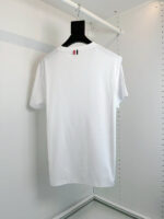 T-shirt bianco semplice con dettagli a strisce colorate, ideale per look casual e moderno.