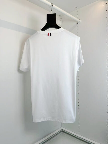 T-shirt bianco semplice con dettagli a strisce colorate, ideale per look casual e moderno.