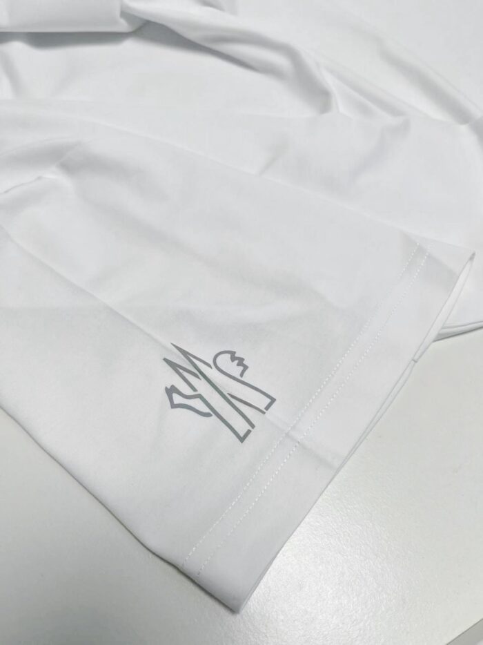 Camicia bianca elegante con emblema minimalista di forbici e cuore, stile sofisticato e versatile.