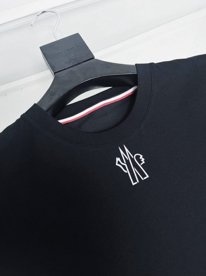 Maglietta nera con logo bianco, colletto con dettaglio colorato, stile minimalista e moderno.