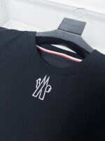 T-shirt nero con logo geometrico bianco e dettaglio colorato sul colletto, stile casual e moderno.