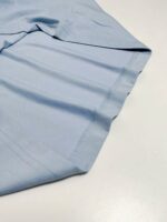 Tessuto leggero blu chiaro in cotone, ideale per abbigliamento casual e confortevole.