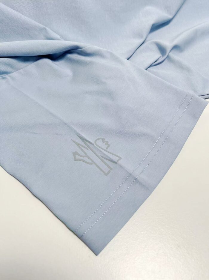 Maglietta azzurra in cotone con logo embossé, stile casual e versatile.