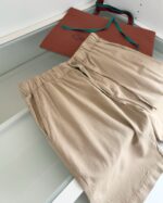 Shorts beige estivi con borsa elegante colorata, stile casual e sofisticato.