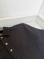 Maglietta polo nera uomo con logo minimalista, collare classico e dettagli eleganti.