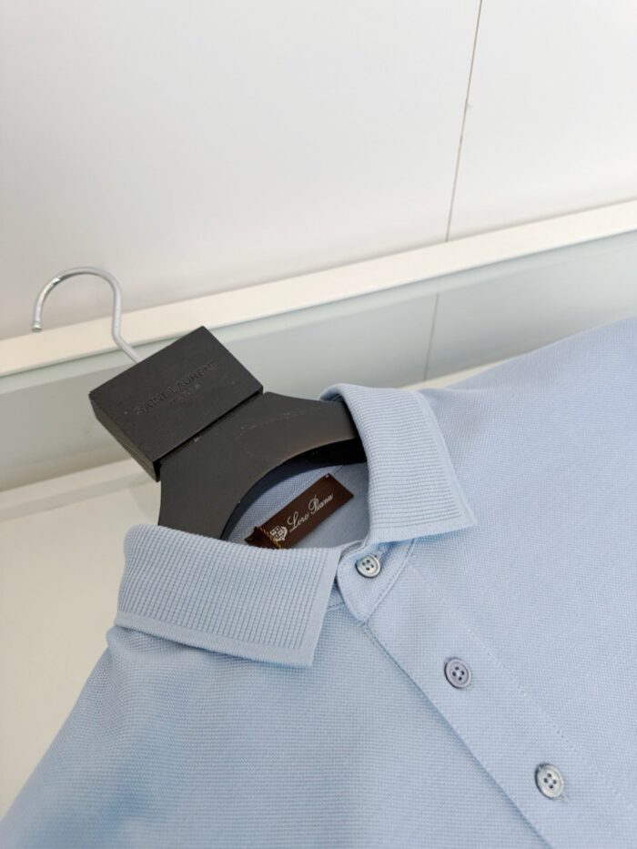 Maglietta polo azzurro chiaro elegante su gancio nero, stile classico e dettaglio raffinato