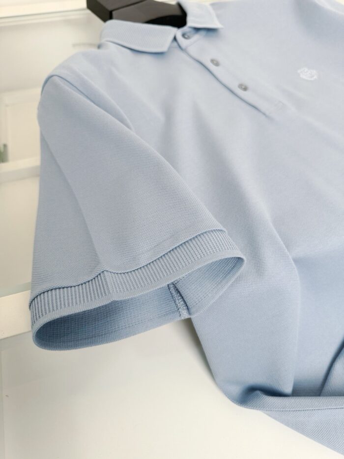 Maglietta polo azzurra elegante in cotone, ideale per look casual e sofisticati.