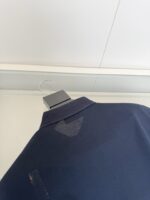 Camicia polo navy con imperfezioni, stile casual e tessuto traspirante su manichino semplice.