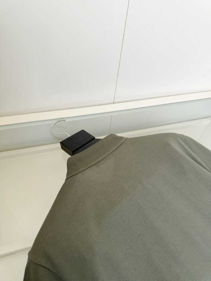Camicia verde oliva con colletto elegante, dettagli moda casual e stile raffinato in showroom.