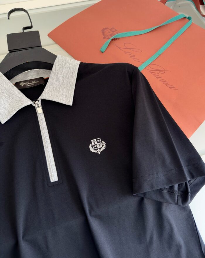 Polo nero elegante con logo, accompagnata da elegante borsa regalo color corallo.