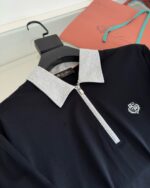 Maglietta polo uomo navy con zip, colletto grigio e dettagli eleganti per uno stile moderno.