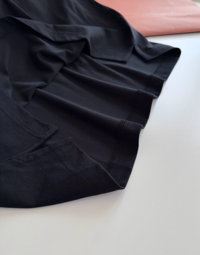 Tessuto nero elegante con dettagli di tessuti rosa chiaro, stile sofisticato e contrasto di texture.