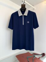 Maglietta polo navy con colletto grigio, logo ricamato e zip frontale elegante.