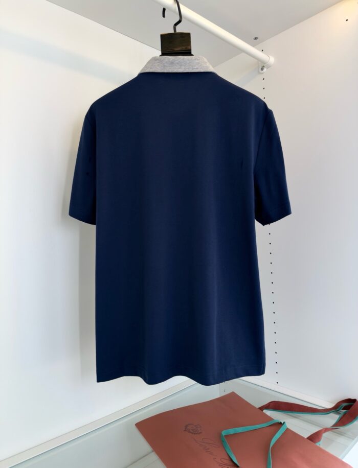 Maglietta polo navy elegante su attaccapanni minimalista, stile classico e raffinato.