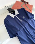 Maglietta polo blu navy con colletto contrasto, eleganti dettagli e packaging di lusso.