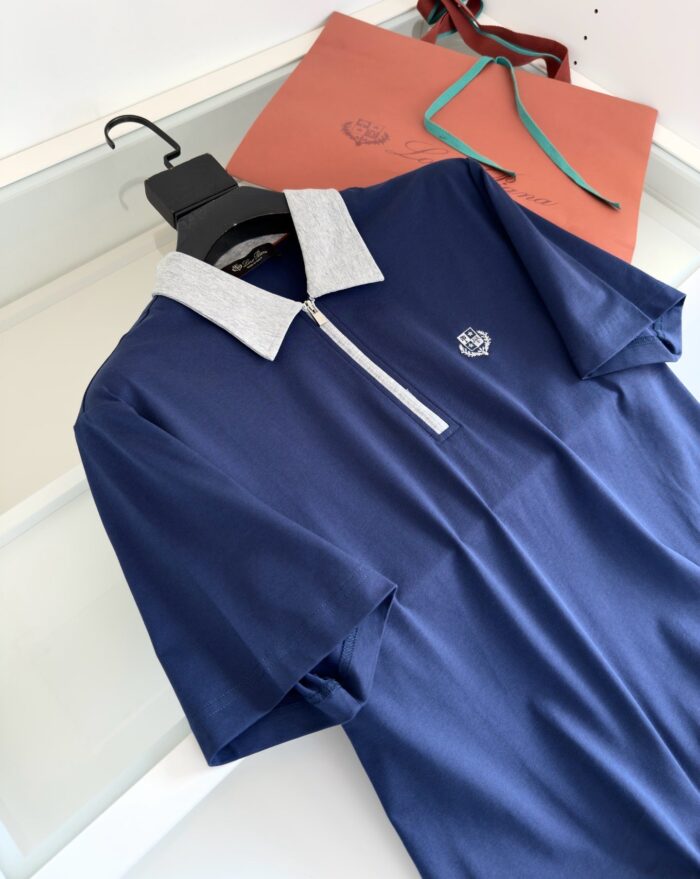 Maglietta polo blu navy con colletto contrasto, eleganti dettagli e packaging di lusso.
