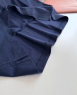 Tessuto navy blu morbido e raffinato con pieghe eleganti e contrasti di colore delicati.