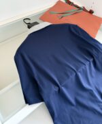 Maglietta polo navy con accessorio colorato, stile casual elegante e pratico.