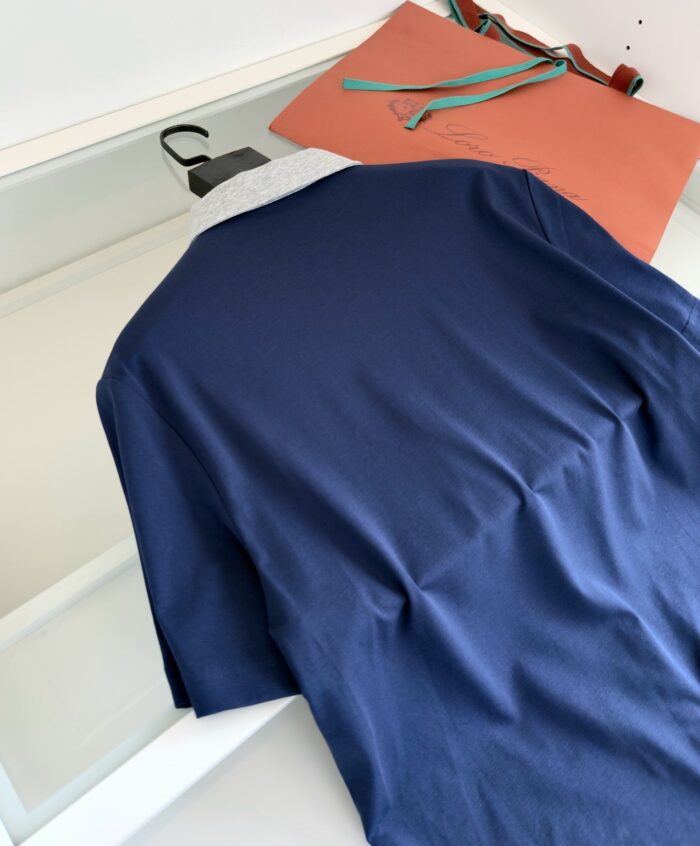 Maglietta polo navy con accessorio colorato, stile casual elegante e pratico.