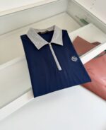 Maglietta polo blu navy con colletto grigio e dettaglio zip, elegante e moderna.