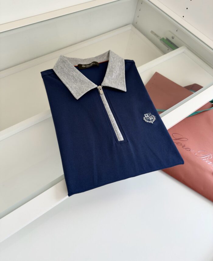 Maglietta polo blu navy con colletto grigio e dettaglio zip, elegante e moderna.