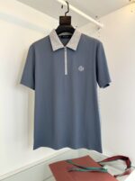 Maglietta polo grigia con zip e colletto a contrasto, stile moderno e versatile.