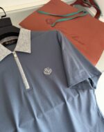 Completo casual elegante con polo blu e borsa coordinata in tonalità calde e raffinate.