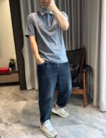 Persona in abbigliamento casual stile moderno in interno elegante con luce naturale.