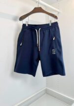 Pantaloncini sportivi blu navy con elastico, tasche e logo discreto, ideali per il relax e l’attività.