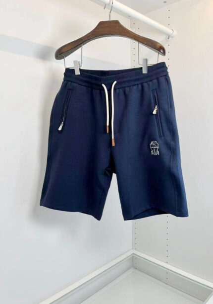 Pantaloncini sportivi blu navy con elastico, tasche e logo discreto, ideali per il relax e l’attività.