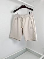 Pantaloncini casual beige con elastico, zip e tasche pratiche in stile minimalista.