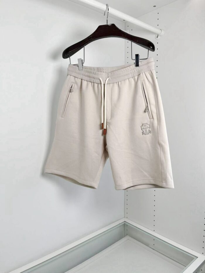 Pantaloncini casual beige con elastico, zip e tasche pratiche in stile minimalista.