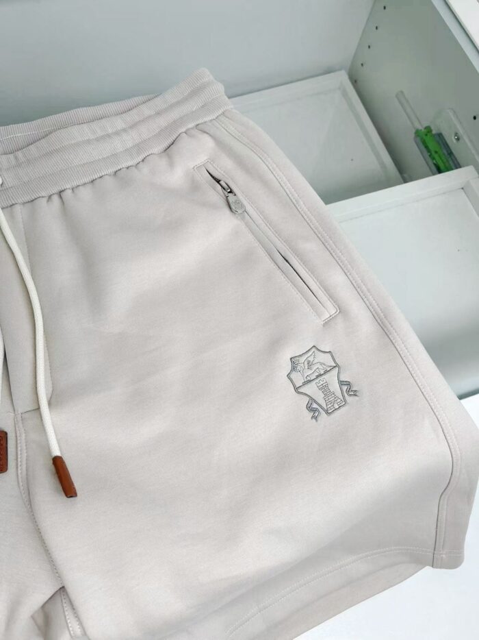 Pantaloncini casual con logo ricamato, coulisse in legno e tasca con zip.